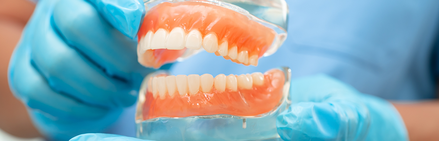 Close up of gloved hands and dentures in Arlington