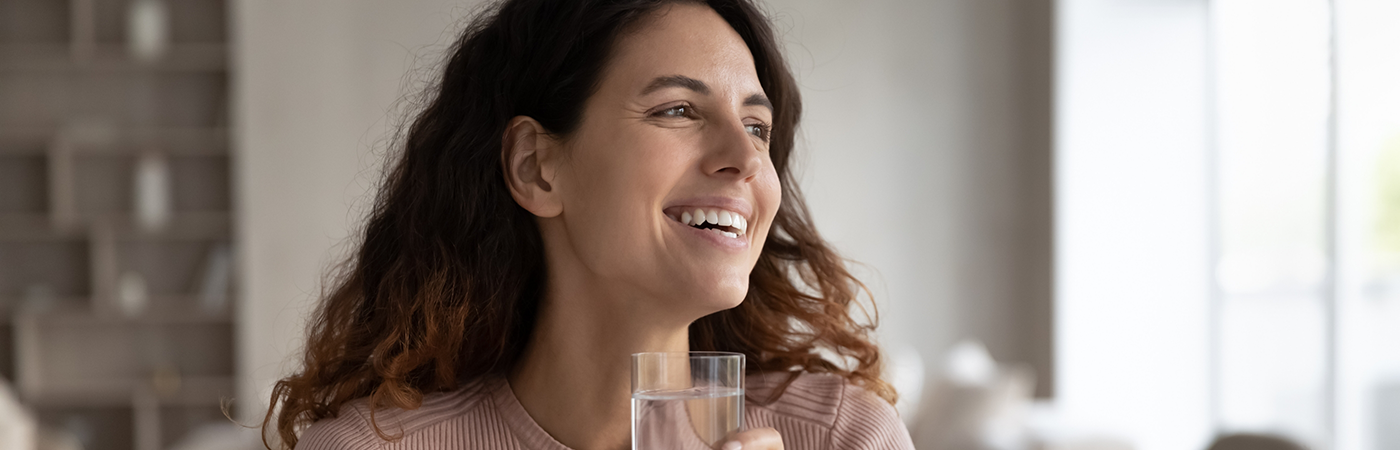 Smiling woman with glass of water