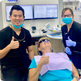 Dentists and patient giving thumbs up