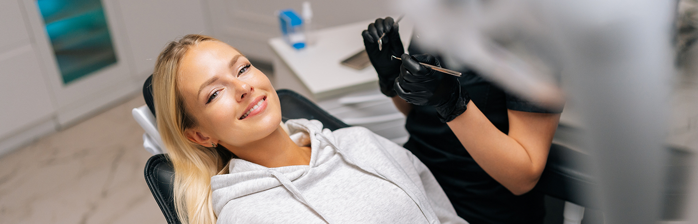 Blonde female dental patient sitting back in chair and smiling